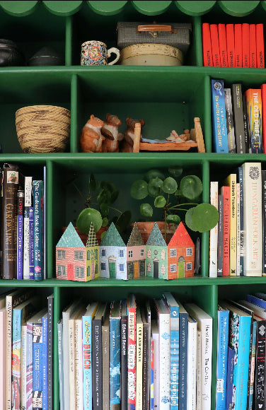 Aufklappbare Leporello-Karte mit sechs bunt illustrierten Häusern; steht als kleine Häuserzeile, Umschlag im Hintergrund