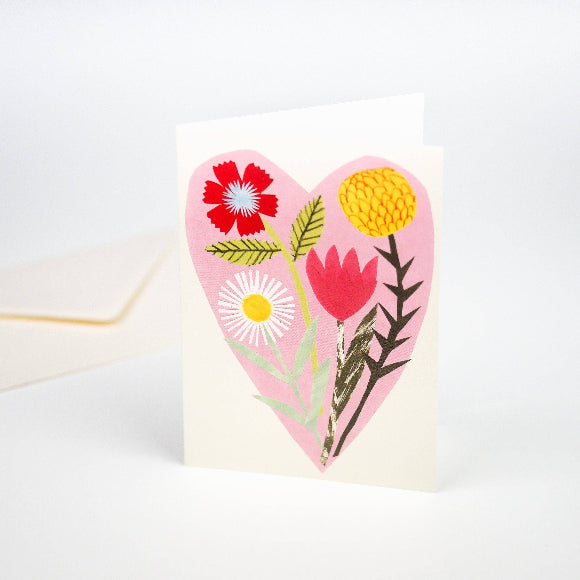 Grußkarte mit rosa Herz und hand-collagierten Wildblumen; 11,5 × 15 cm auf 300-g/m² Karton, elfenbeinfarbener Umschlag im Hintergrund