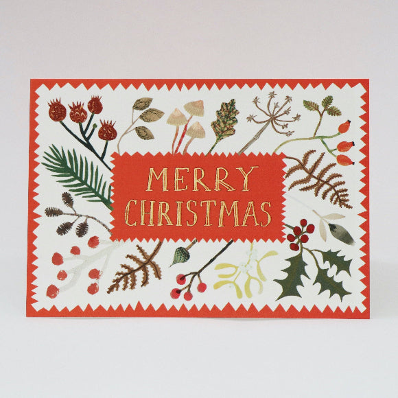 Weihnachtskarte mit rotem „Merry Christmas“-Schriftfeld, umrahmt von collagierten Winterblättern, Beeren und Zweigen auf hellem Grund