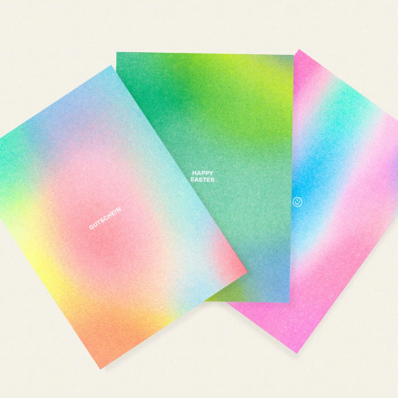 Gutschein-Postkarte mit buntem Farbverlauf und weißer Aufschrift „GUTSCHEIN“ von HERR & FRAU RIO.